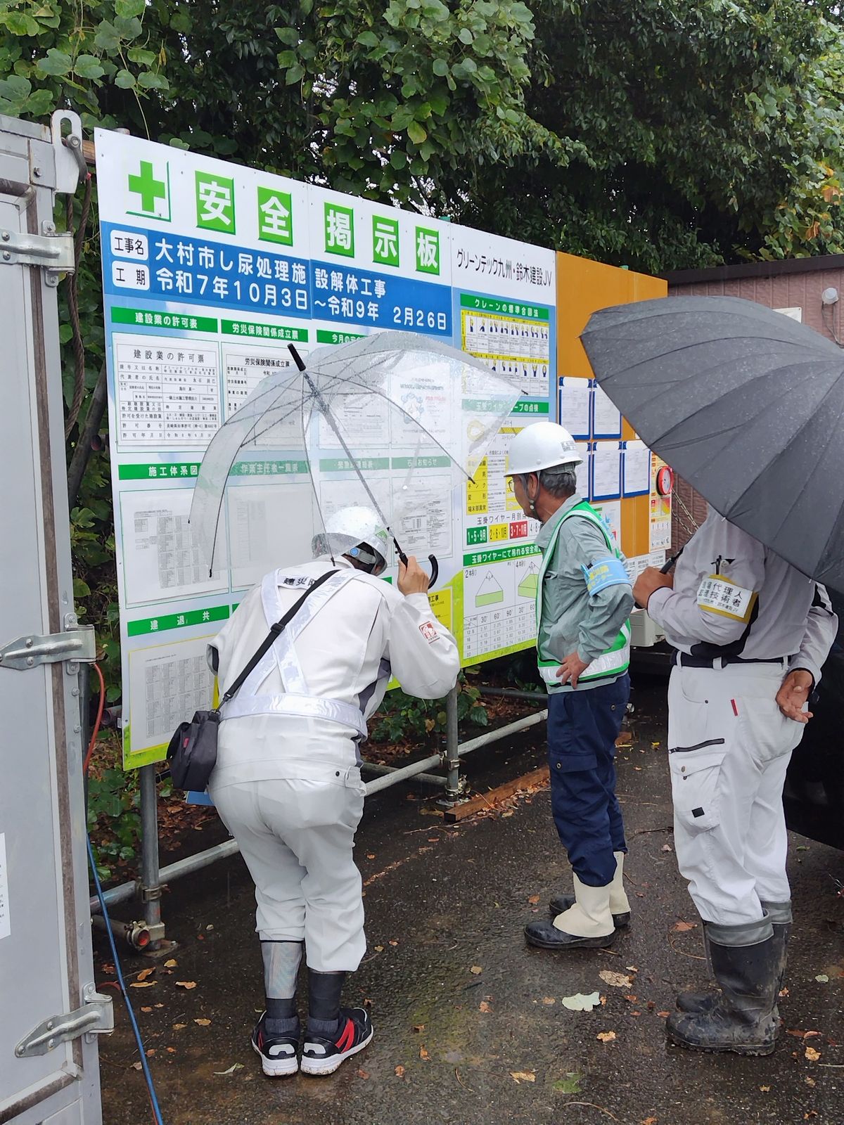 工事現場の安全掲示板を確認する様子